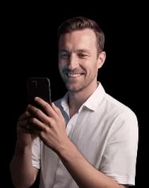 Mosolygós férfi mobiltelefonnal.