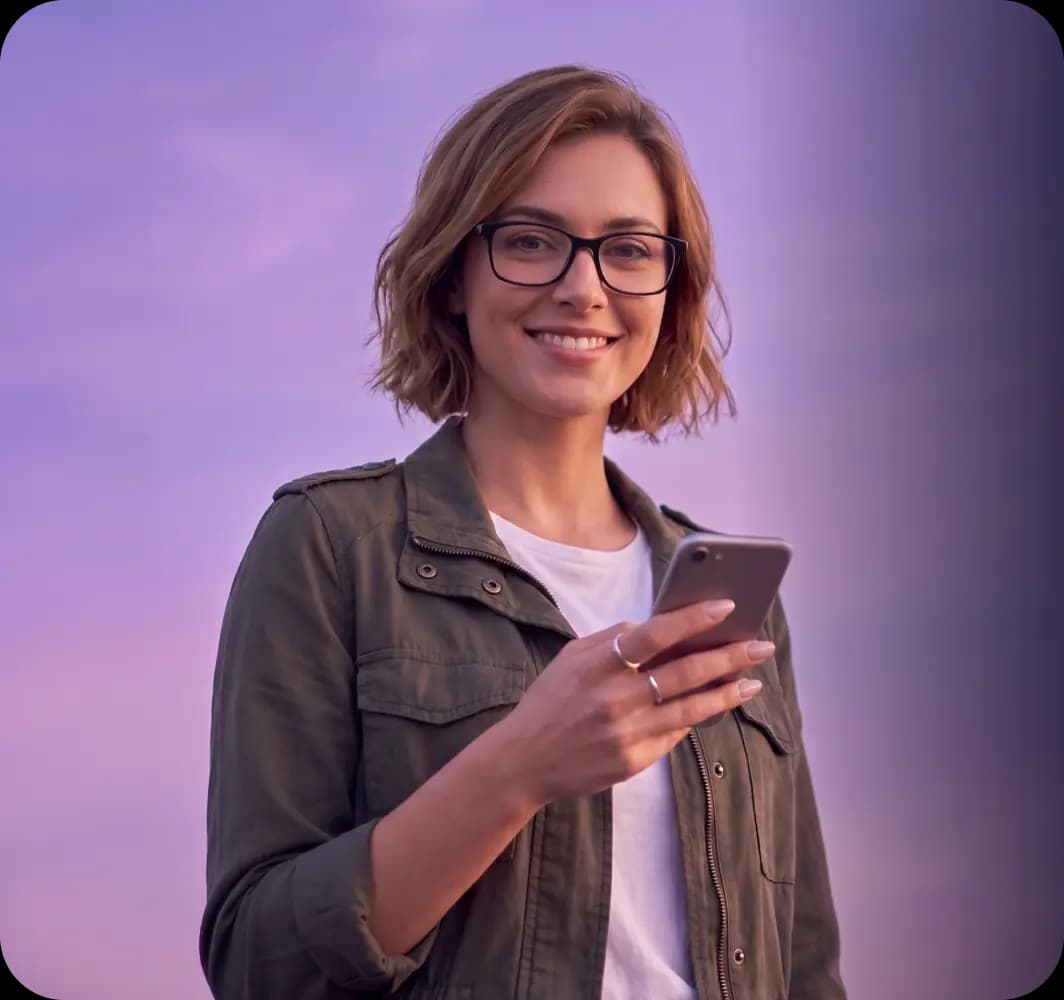 Mosolygó, szemüveges nő mobiltelefonnal