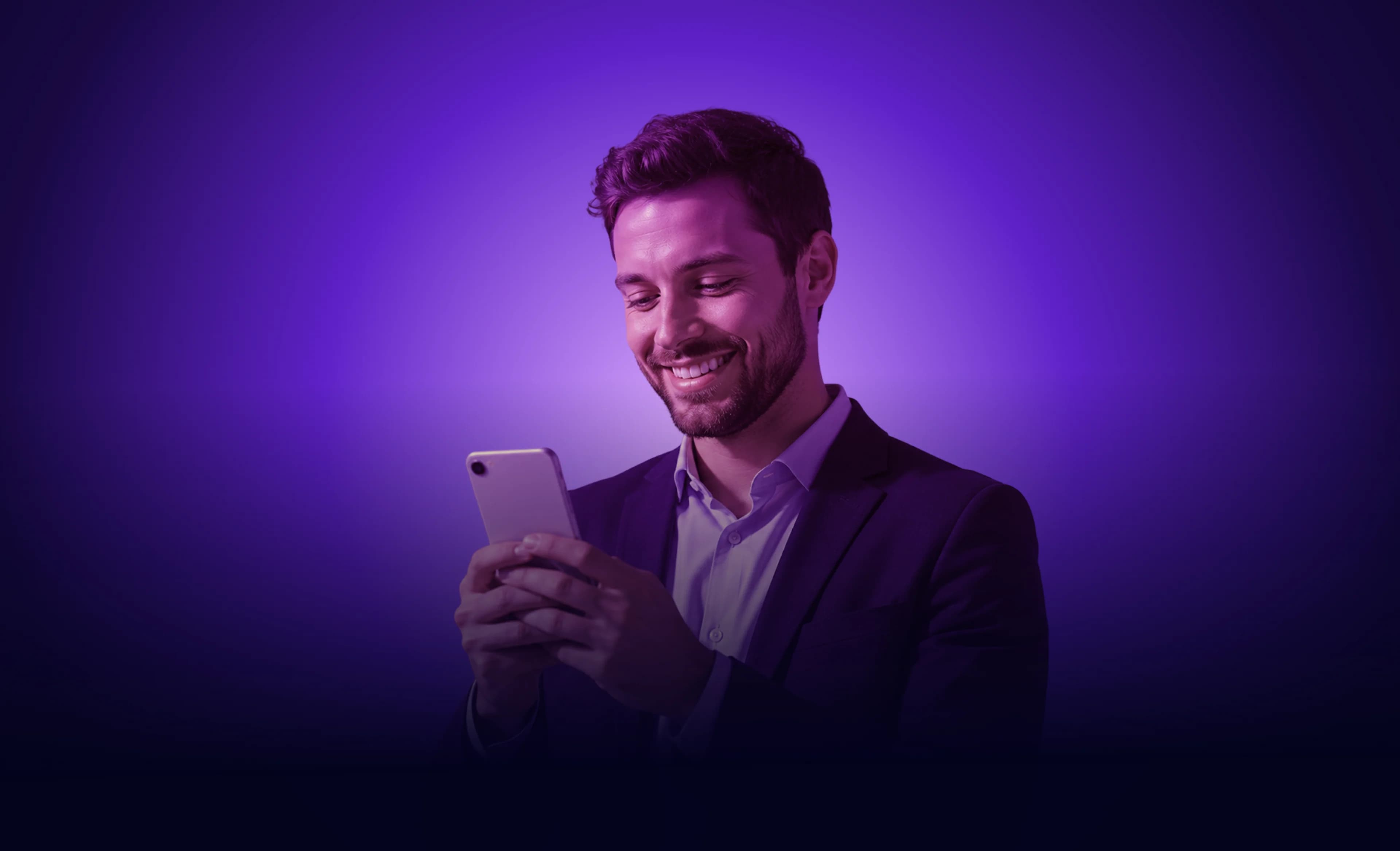 Mosolygó férfi mobiltelefonnal a kezében
