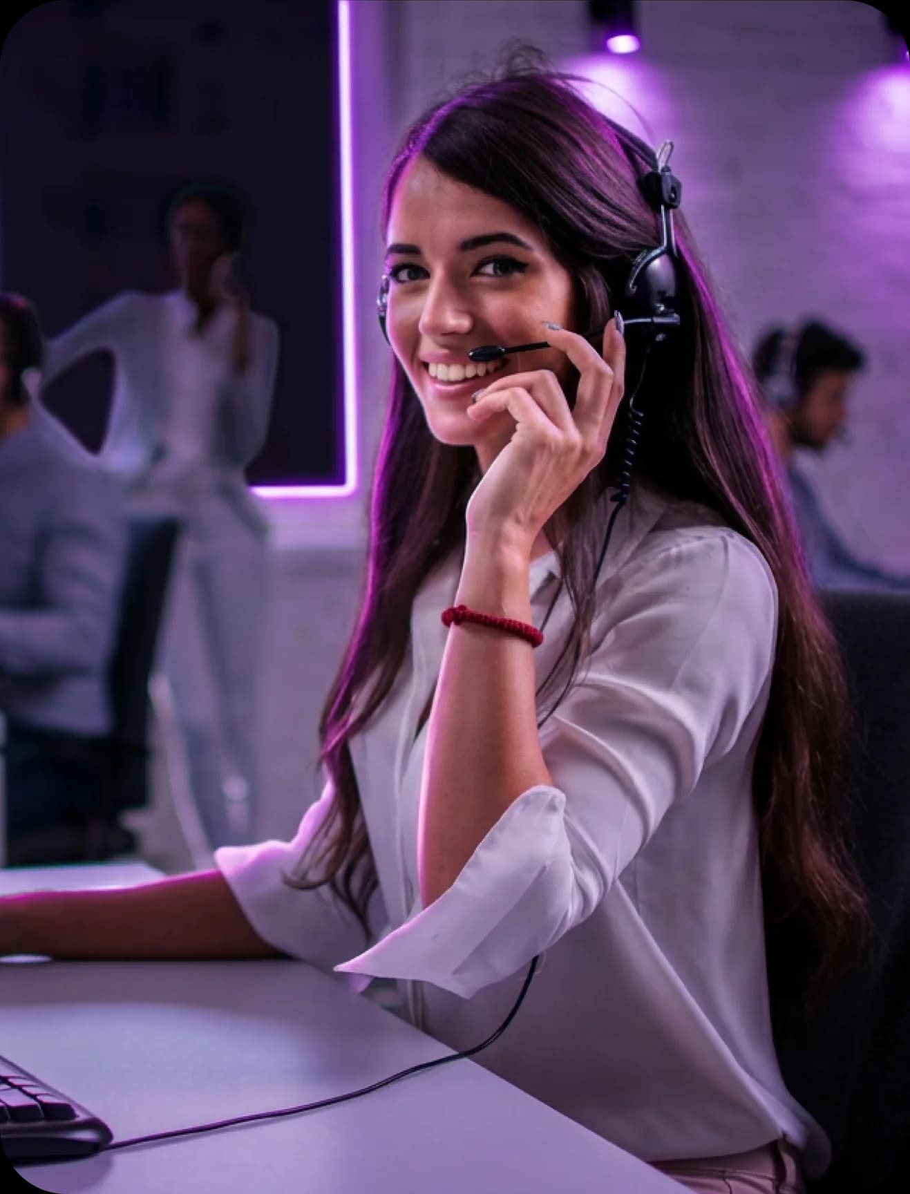Headsetet viselő ügyfélszolgálati munkatárs telefonál az irodában.