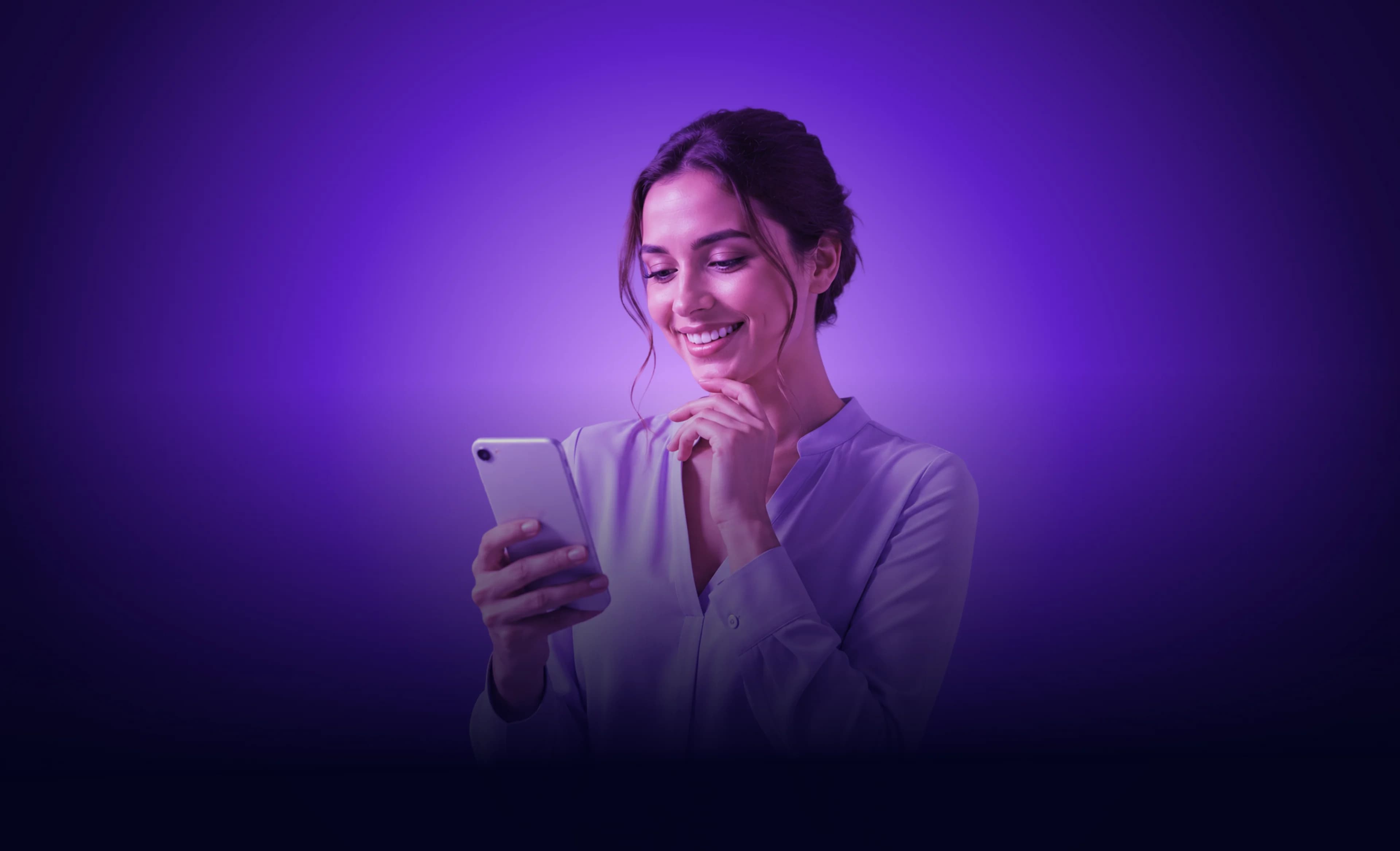 Mosolygó nő mobiltelefonnal a kezében