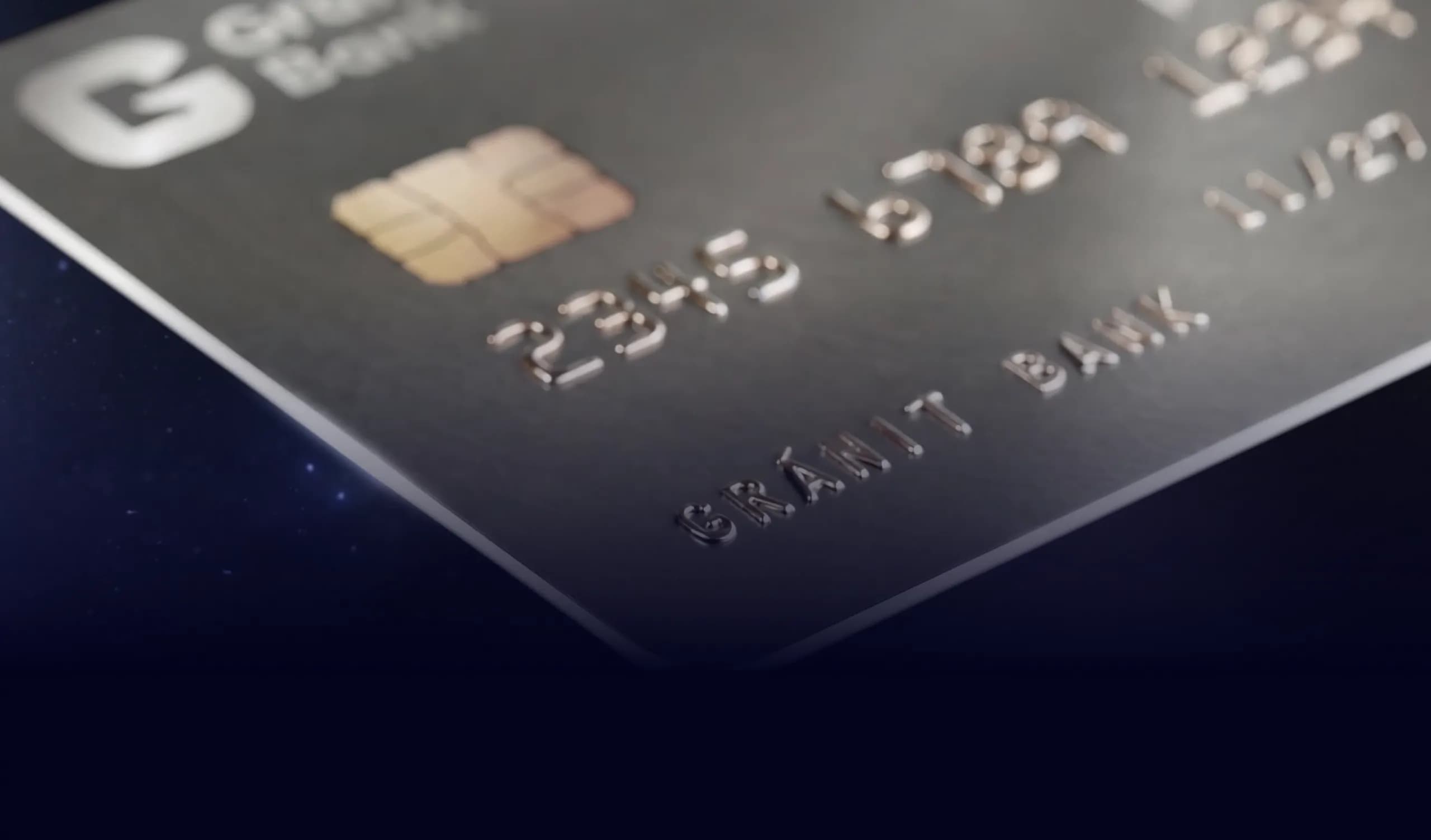 Sötétszürke fém bankkártya közelképe csippel, dombornyomott kártyaszámmal és Gránit Bank felirattal, sötétkék, csillagos háttér előtt